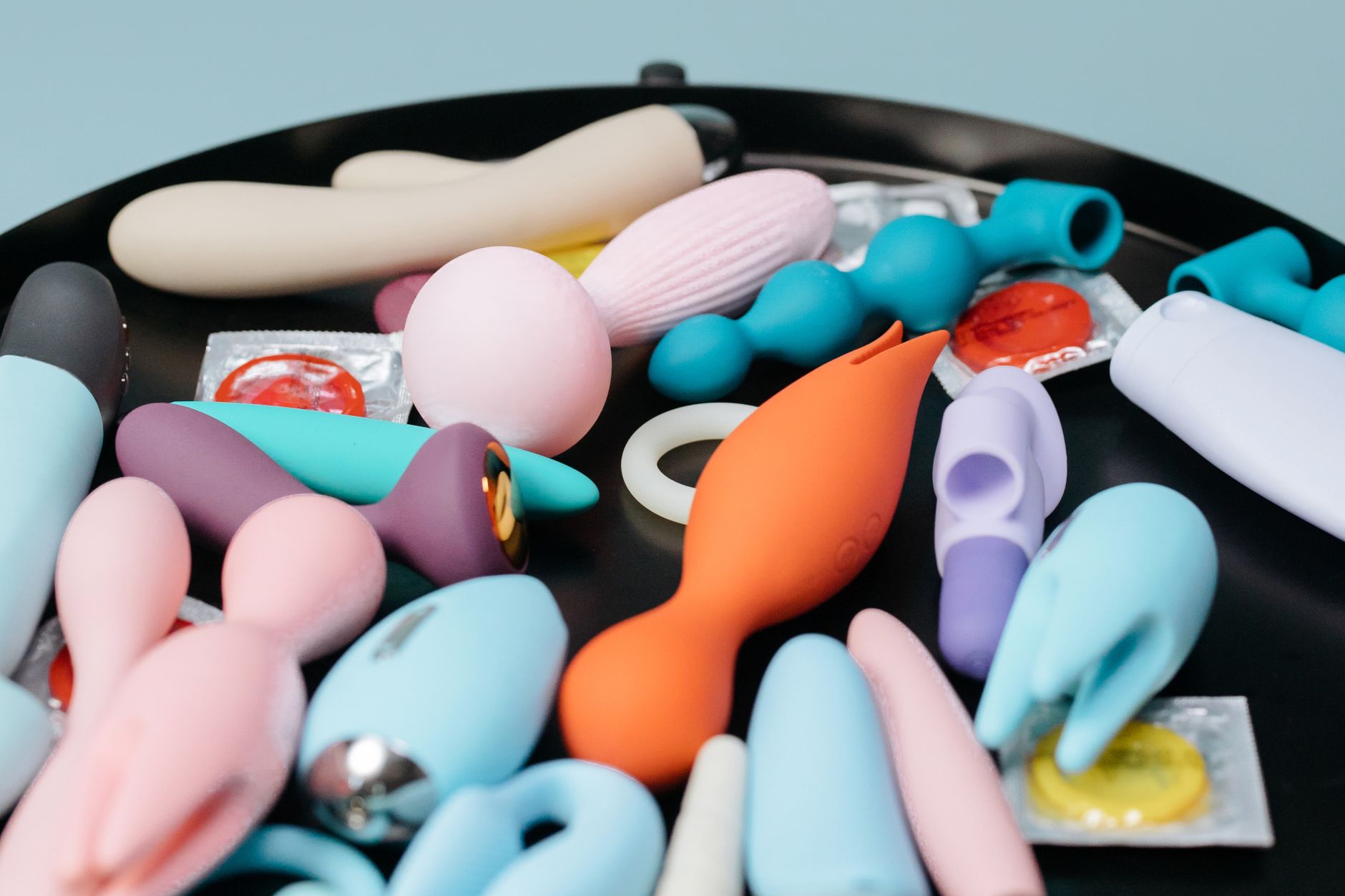 Three colorful vibrators arranged on white fabric, highlighting their smooth texture