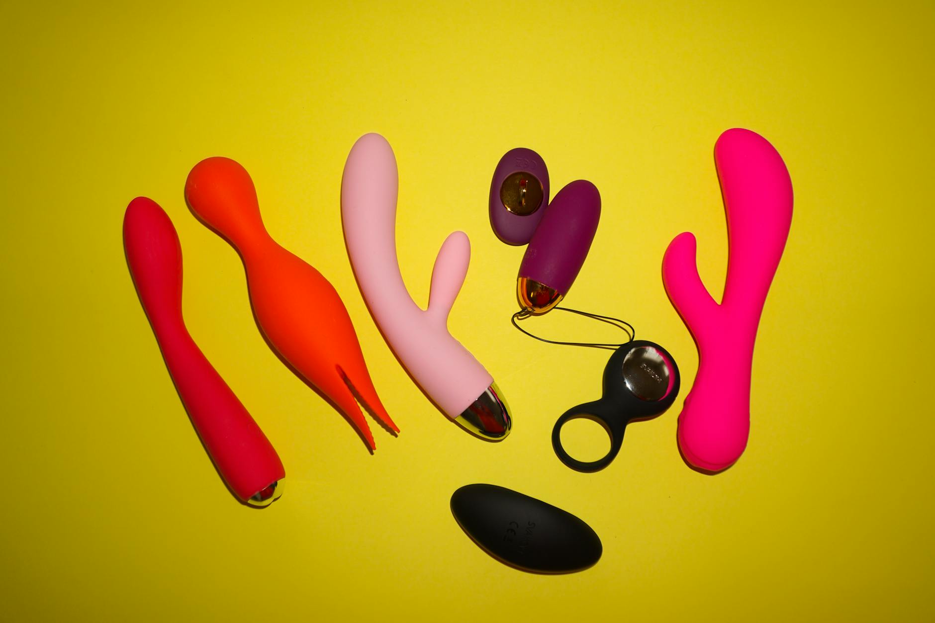 A sleek teal vibrator resting on soft white silk fabric