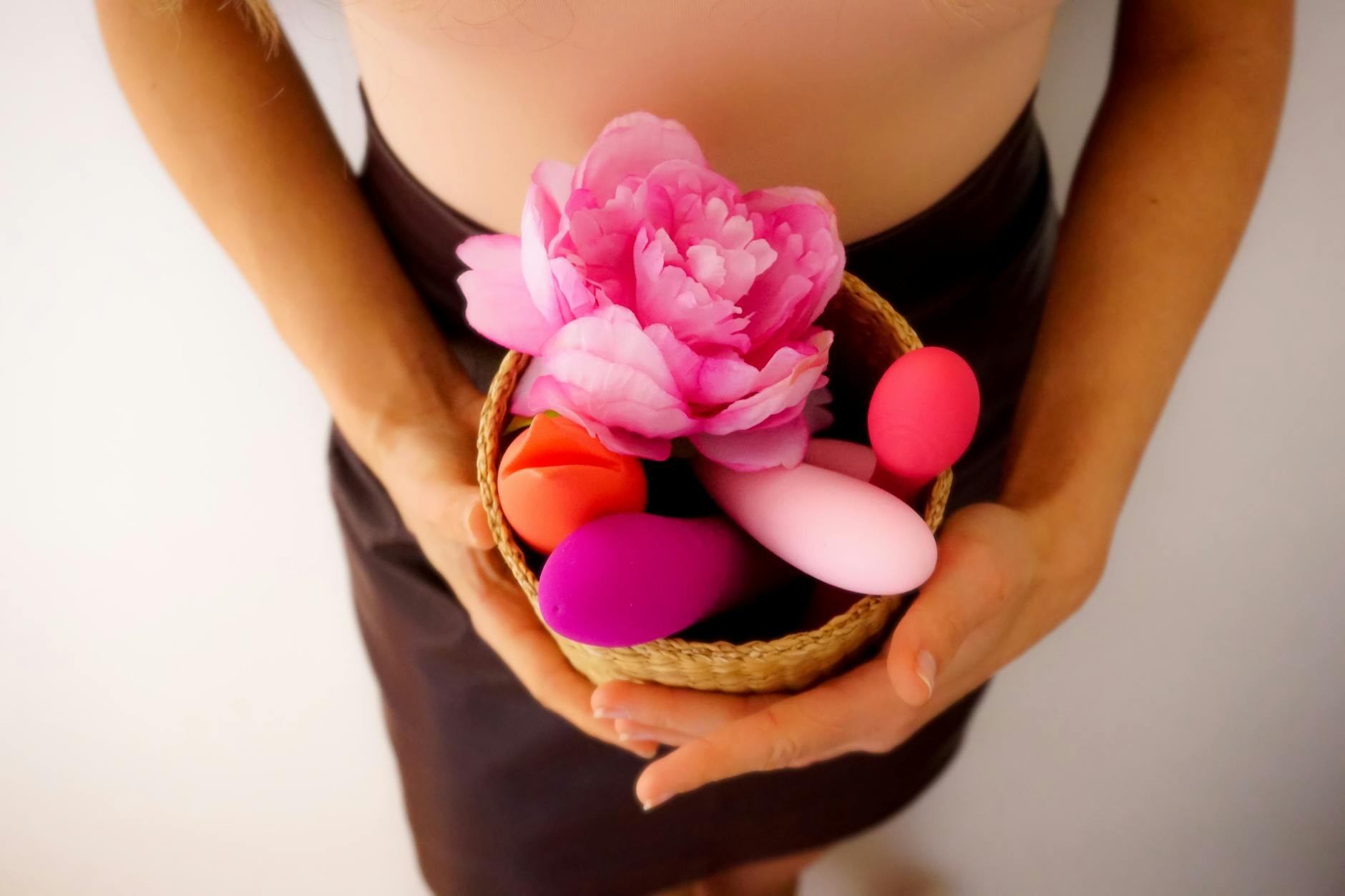 A basket of colorful clitoral vibrators and flowers, symbolizing desire and intimacy