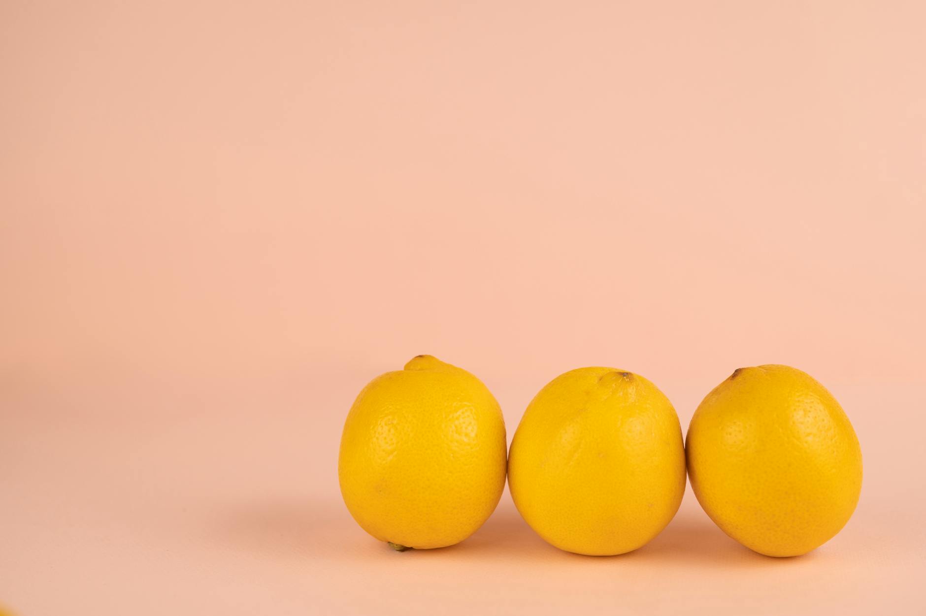 Close-up of hands holding a sleek orange vibrator against a minimalist purple backdrop